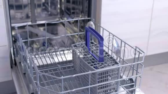 人把白色餐具和餐具放在洗碗机的篮子里高速视频的预览图
