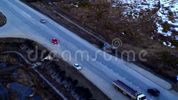 日落时骑在一个巨大的立交桥上的红色汽车的鸟瞰图视频的预览图