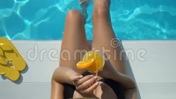 戴大帽子的女士玩水喝鸡尾酒夏日休闲视频的预览图