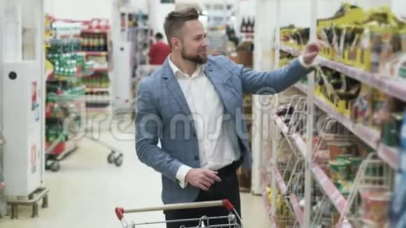 快乐的年轻微笑夫妇选择杂货和在超市购物视频的预览图