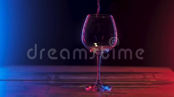 站在木桌上的酒杯里倒着红酒慢动作视频的预览图