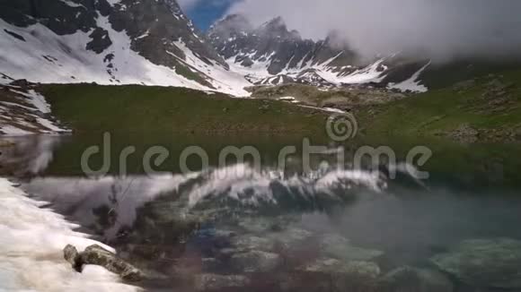 一个被群山环绕的清澈湖泊的时间推移云在滚滚视频的预览图