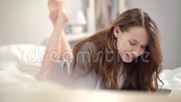 年轻女子在网上视频通话中交谈微笑的女人用手机视频的预览图
