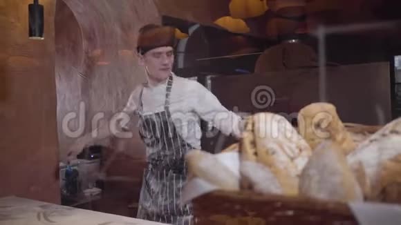 专业厨师旋转和投掷比萨饼面团在厨房的餐厅刚出炉的面包放在篮子里视频的预览图