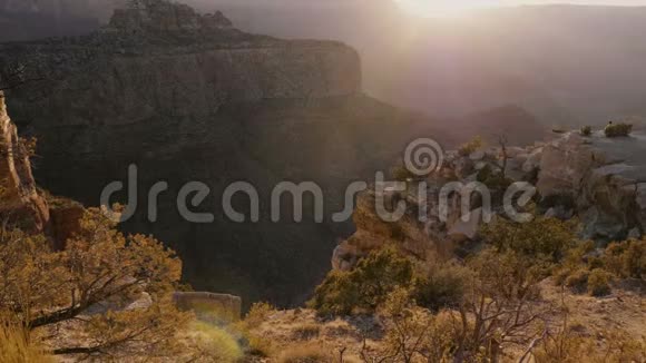 相机在岩石上的灌木丛上移动以揭示史诗般的日落背光全景令人惊叹的大峡谷山脉美国视频的预览图