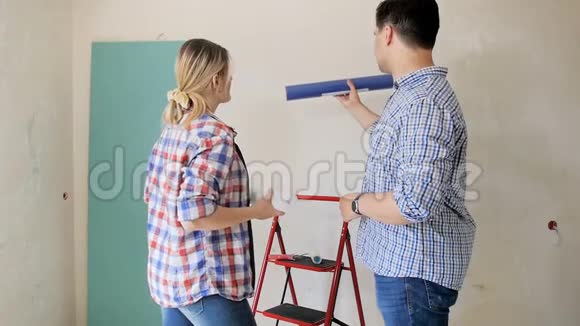 幸福的微笑夫妇为他们正在装修的新公寓选择壁纸的镜头视频的预览图