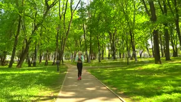 年轻有魅力和运动的金发女孩在公园户外慢跑保健体育健身和生活方式视频的预览图