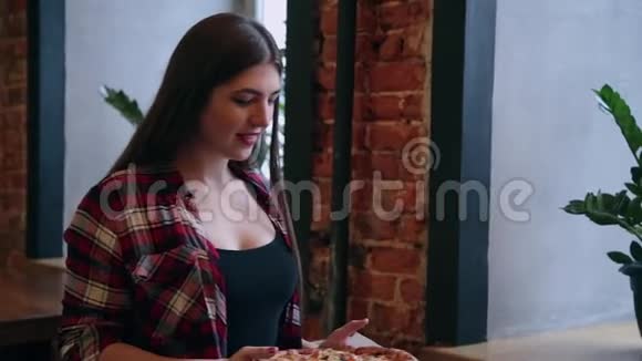 漂亮的商务女性把披萨放在桌子上但要花一台笔记本电脑视频的预览图