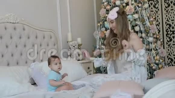 年轻的母女在新年的早晨在家里床上视频的预览图