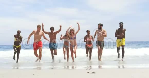 混合种族朋友一起在海滩上跑步的正面景色视频的预览图