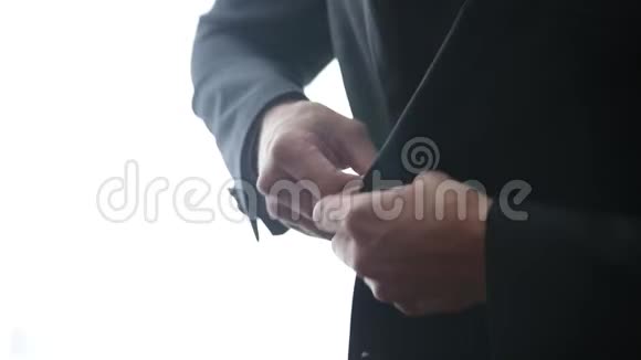 扣上一件夹克穿西装的时髦男人把扣子系在夹克上准备出门视频的预览图