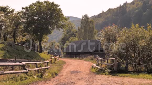 乡村景色地面道路背景上有山夏在村里山村的木栅栏视频的预览图