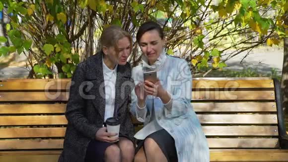 两名年轻女子在智能手机上观看照片视频的预览图