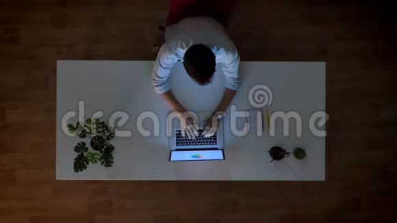 工作人员坐在桌子旁看着笔记本电脑和打字动作轻快时间快视频的预览图