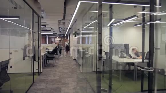 员工用玻璃隔断在现代办公室工作和走动视频的预览图