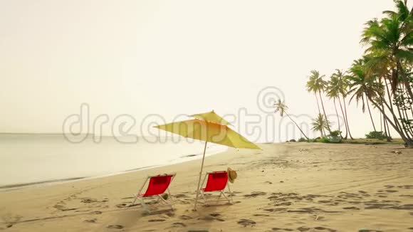 沙滩椅和太阳伞岛上海滩日落视频的预览图