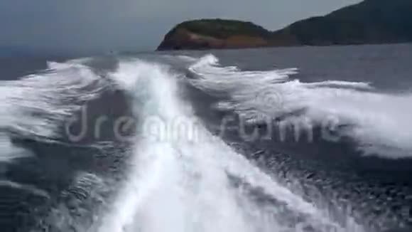 从一艘高速船的发动机上波浪后景蓝天白云和远岛视频的预览图