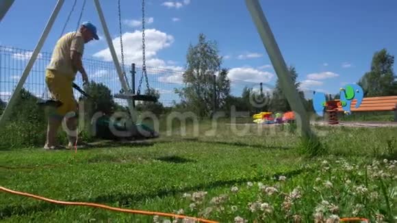 年轻人在儿童操场上割草万向节运动视频的预览图