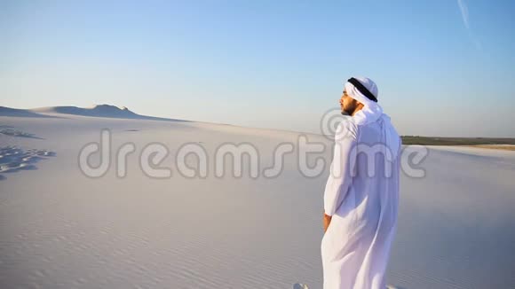 在晴朗的一天阿拉伯阿联酋酋长盖伊在沙漠中的白沙上缓慢移动到桑迪山顶视频的预览图