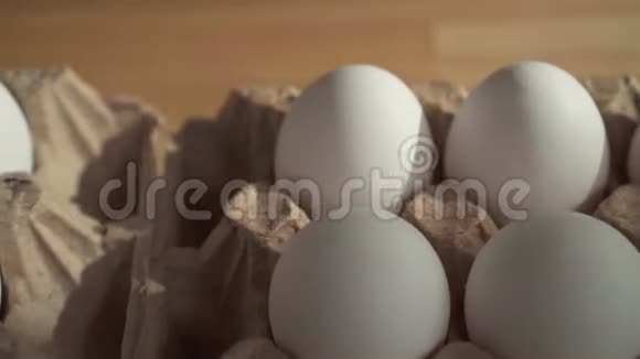 把几个鸡蛋放在桌上的纸板箱里视频的预览图