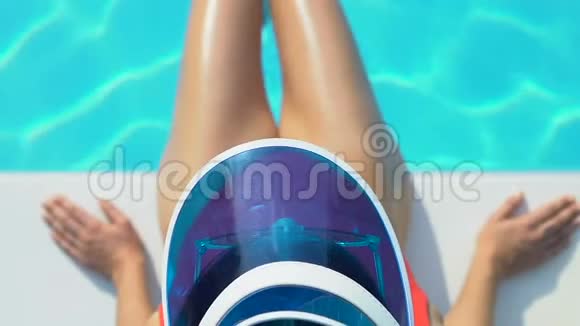 戴着帽子和太阳镜的女性在游泳池附近玩水度假视频的预览图