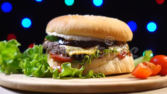 自制和新鲜美味的汉堡与奶酪番茄生菜在彩色模糊的背景视频的预览图