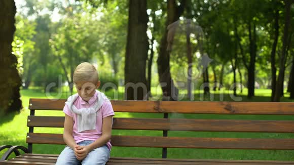 男孩记得死去的祖父看着他的鬼魂坐在长凳上孤独和悲伤视频的预览图