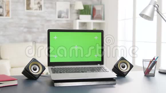 桌面上有绿色屏幕的笔记本电脑明亮明亮的客厅空间视频的预览图