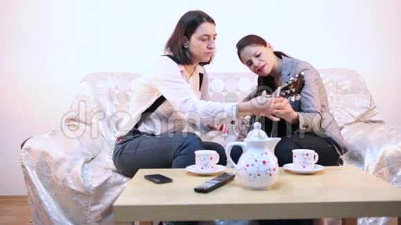 女人教她的朋友吉他视频的预览图