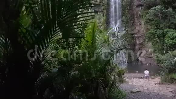 站在森林中一个巨大瀑布前的少女视频的预览图