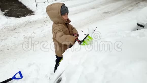暴雪后幼儿用刷子帮幼儿清洁车从雪中清洁车4k视频视频的预览图