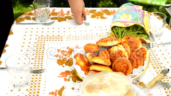 一位女士在户外为一家人准备午餐把青葱和蔬菜放在一个美丽的糕点旁边视频的预览图