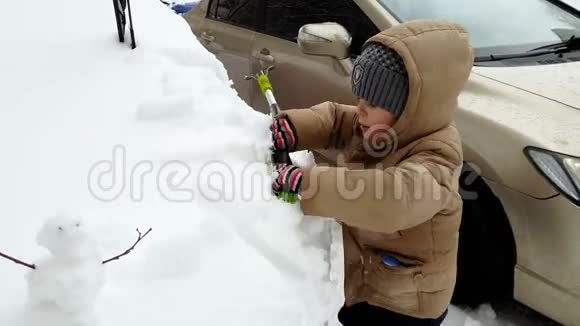 4K小男孩用刷子帮他父亲擦雪车的镜头视频的预览图