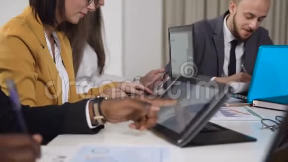 多民族青年商务人士的特写他们坐在会议桌旁用电脑工作视频的预览图