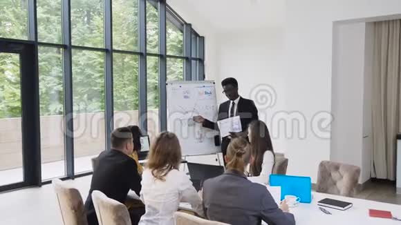 美国非洲男性经理在会议上向同事介绍新项目计划向同事解释新想法视频的预览图