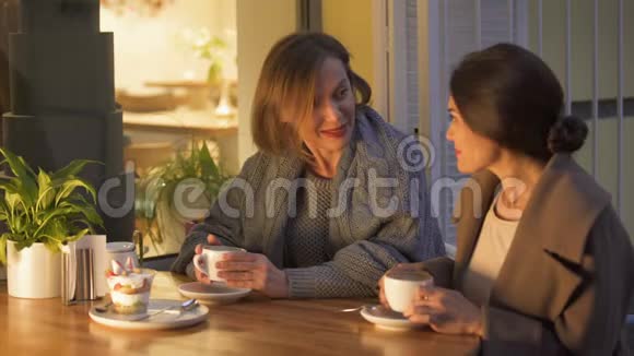 快乐的女性朋友坐在咖啡馆里聊天在一起愉快视频的预览图