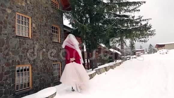 新郎旋转快乐的新娘抱着她把她在他的手中旋转在雪天气附近的滑雪胜地村舍快乐视频的预览图