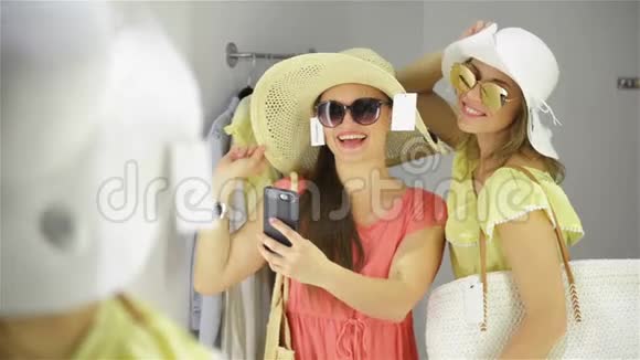 快乐的女人在服装店里穿着新的太阳镜有乐趣购物的女性朋友视频的预览图
