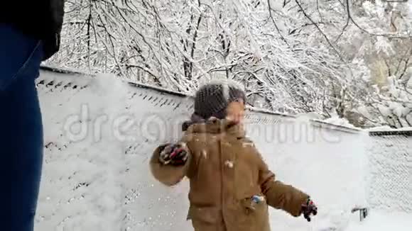 4K镜头欢快的小男孩在冬季公园享受和玩雪视频的预览图