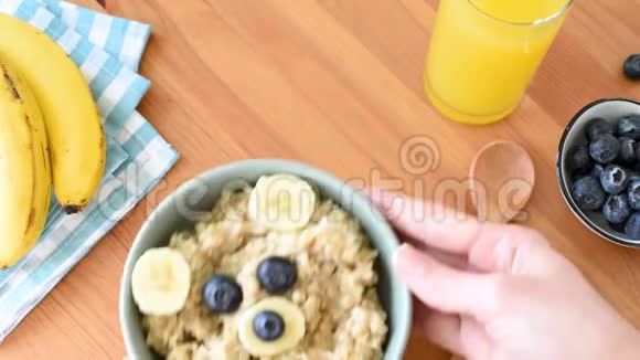 女人把早餐燕麦碗放在桌子上视频的预览图