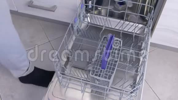 人装洗碗机把餐具和厨具放在篮子里高速视频的预览图