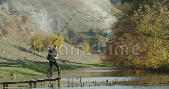 钓鱼人在令人惊叹的美丽地方秋天的小泄漏和完美的晴天4k视频的预览图