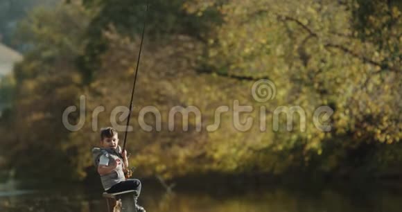小男孩有魅力的脸玩着棍子直到他教如何抓住鱼视频的预览图