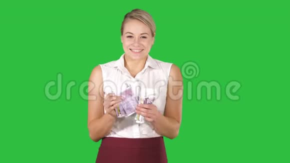美丽快乐的女孩与欧元帐单在绿色屏幕铬钥匙视频的预览图