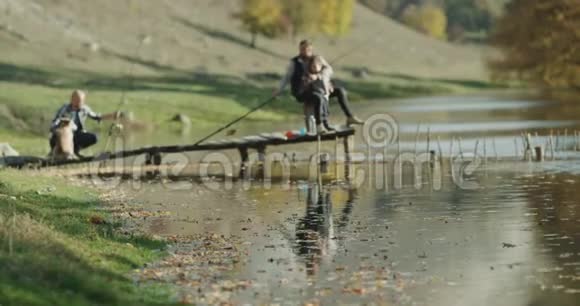 湖边风景优美两个朋友带着一个小男孩和一只可爱的哈士奇狗准备出发视频的预览图