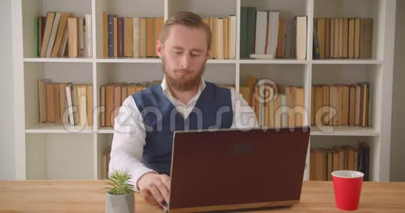 年轻的高加索商人在笔记本电脑上打字的特写照片在办公室里她体贴入微视频的预览图