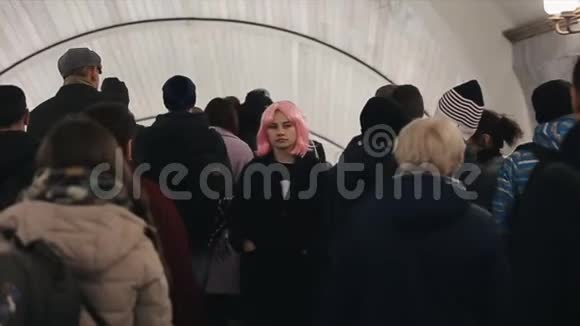 美丽的白种人年轻女孩粉红色的头发穿过人群在地铁里有粉色头发的漂亮女人视频的预览图