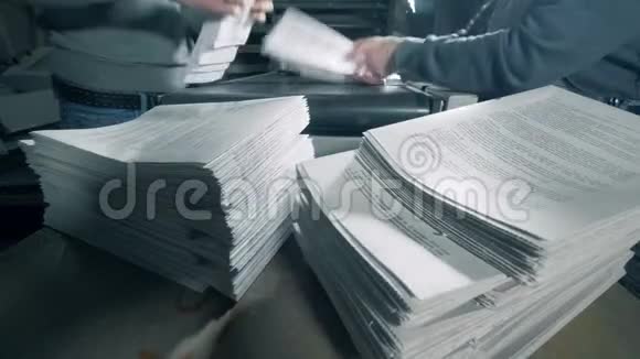 工人们把纸堆在印刷设施里视频的预览图