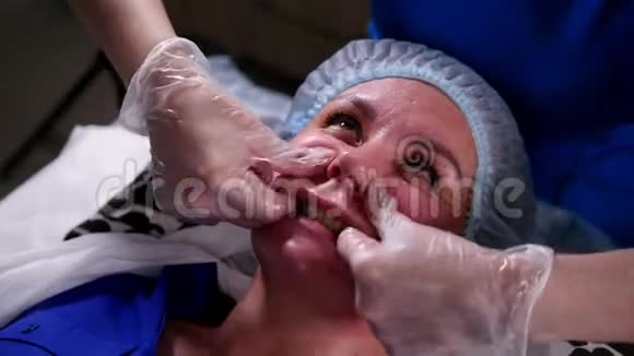 美容诊所年轻女子接受抗衰老面部按摩按摩鼻唇皱褶视频的预览图