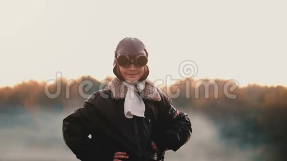 美丽的肖像小女孩在旧的飞行员飞行夹克和眼镜在日落概念勇气慢动作视频的预览图